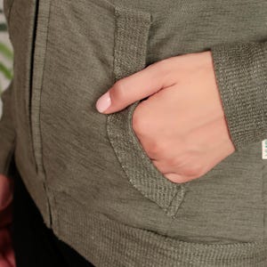 Puede incluir: Una chaqueta verde con cremallera y un bolsillo en la parte delantera. La chaqueta tiene un dobladillo y pu&ntilde;os de canal&eacute;.
