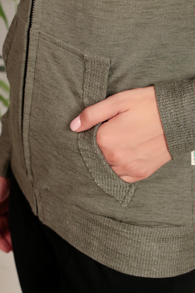 Puede incluir: Una chaqueta verde con cremallera y un bolsillo en la parte delantera. La chaqueta tiene un dobladillo y pu&ntilde;os de canal&eacute;.