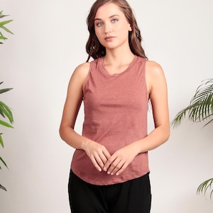 May include: A sleeveless, rust-colored tank top with a relaxed fit. The top is made of a soft, lightweight fabric and has a rounded neckline.