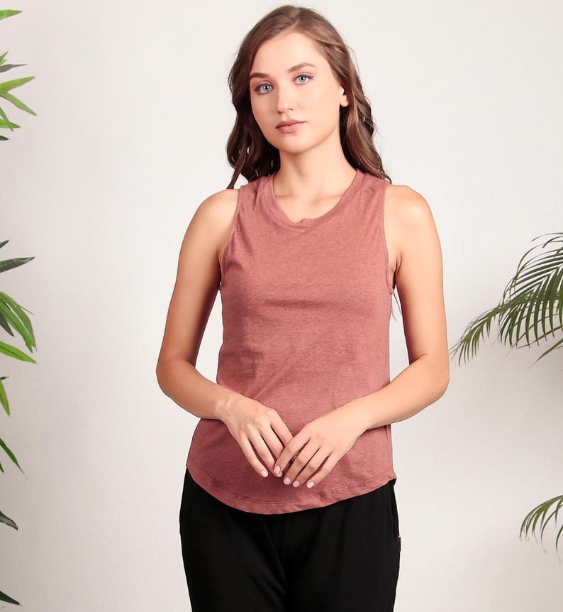May include: A sleeveless, rust-colored tank top with a relaxed fit. The top is made of a soft, lightweight fabric and has a rounded neckline.