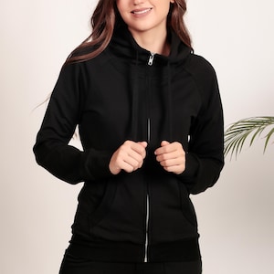 Puede incluir: Una sudadera con capucha negra con cremallera, cuello alto y cord&oacute;n. La sudadera est&aacute; hecha de una tela suave y c&oacute;moda.