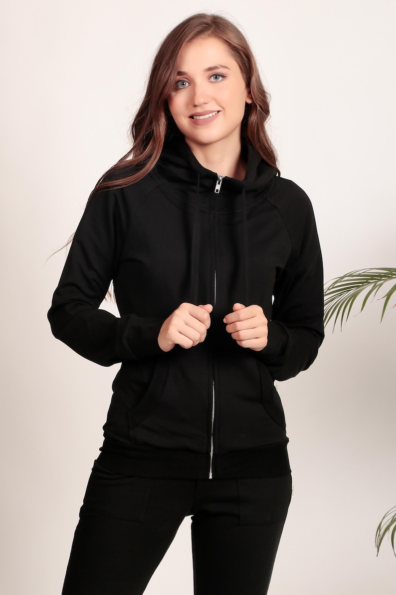 Puede incluir: Una sudadera con capucha negra con cremallera, cuello alto y cord&oacute;n. La sudadera est&aacute; hecha de una tela suave y c&oacute;moda.