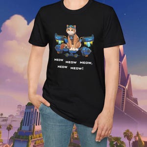 以下が含まれることがあります： ゴーグルとパイロットヘルメットをかぶった漫画の猫が、未来的な乗り物に乗っている黒いTシャツ。テキスト「MEOW MEOW MEOW, MEOW MEOW！」が下に印刷されています。猫はオレンジと白です。