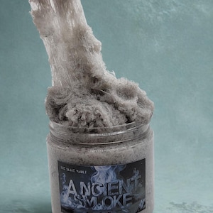 May include: A clear jar filled with gray slime, labeled "Ancient Smoke" with a smoky graphic. The slime is being stretched, revealing its texture. The jar is from "The Slime Vault."