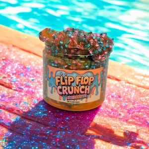 May include: A jar of "Flip Flop Crunch" slime with a colorful label and a clear container. The slime is topped with small, colorful beads and sits near a pool. The label reads "DO NOT EAT" and "THE SLIME VAULT."