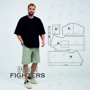 Puede incluir: Una persona con una camiseta negra de gran tamaño y pantalones cortos verde claro. Los pantalones cortos llegan a la rodilla. La persona está de pie junto a un diseño de patrón. El texto "FASHION FIGHTERS" está en la parte inferior de la imagen.