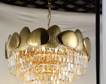 A brand-new, medium-sized round 5 tiered, contemporary chandelier with a leaf crystal and golden finish