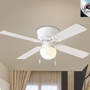 May include: A white ceiling fan with four blades and a central light fitting. The fan blades are angled, and the light has a frosted globe shape. The fan is mounted on a white ceiling.