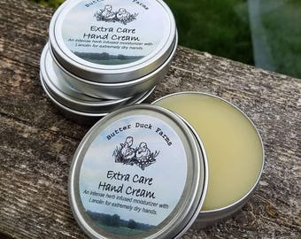 May include: Two silver tins of hand cream with a white label that reads "Butter Duck Farms Extra Care Hand Cream An intense herb infused moisturizer with Lanolin for extremely dry hands."