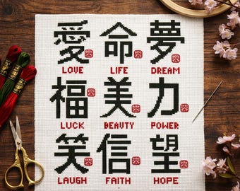 May include: A white cross-stitch fabric featuring nine black Chinese characters arranged in a grid, each paired with a red English word underneath. The words are Love, Life, Dream, Luck, Beauty, Power, Laugh, Faith, and Hope, each with a small red stamp.