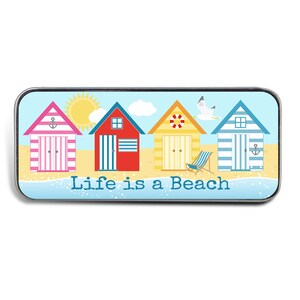 May include: A rectangular metal sign with a blue background and a beach scene. Four colorful beach huts are lined up on a sandy beach with a sun, clouds, and a seagull. The text "Life is a Beach" is printed in blue below the huts.