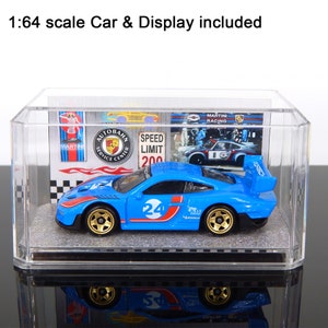 May include: A blue 1:64 scale toy car with gold wheels and the number 24, displayed in a clear acrylic case. The case includes a backdrop with racing-themed graphics and the text "MARTINI RACING".