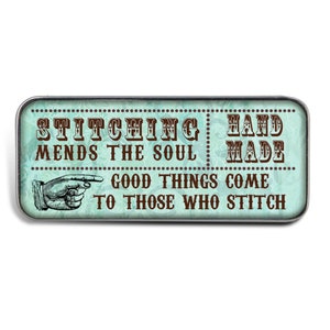 May include: A teal blue and brown rectangular sign with the text "Stitching Mends the Soul" and "Hand Made" with a pointing hand and the text "Good Things Come To Those Who Stitch".