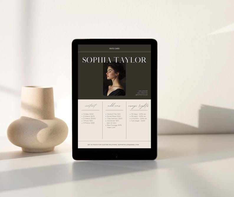 Peut inclure: Une carte de tarifs en noir et blanc avec le texte "Sophia Taylor" en police sans empattement blanche. La carte de tarifs liste les prix de diff&eacute;rents services de photographie, y compris les portraits, les services suppl&eacute;mentaires et les droits d'image.