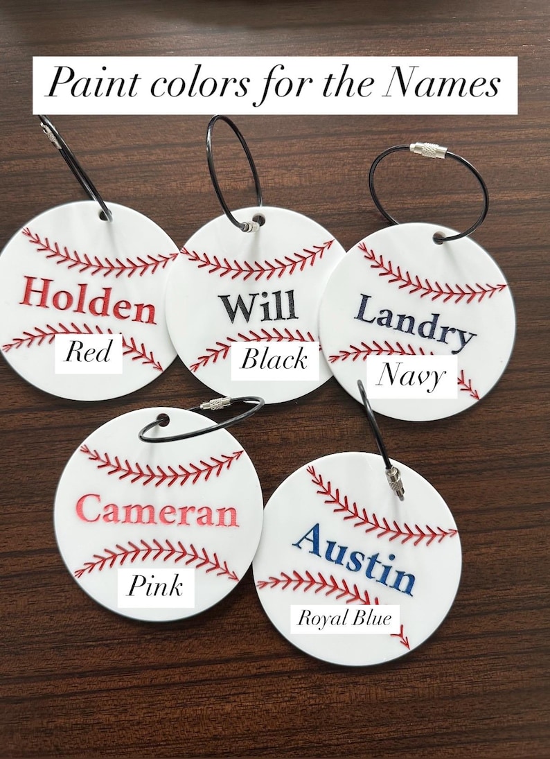 Pu&ograve; includere: Cinque ornamenti bianchi a tema baseball con cuciture rosse e ganci in corda nera. Ogni ornamento ha un nome scritto in diversi colori: Holden in rosso, Will in nero, Landry in blu navy, Cameran in rosa e Austin in blu reale.