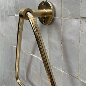 Unlacquered brass wall-mounted towel hanger with golden tone