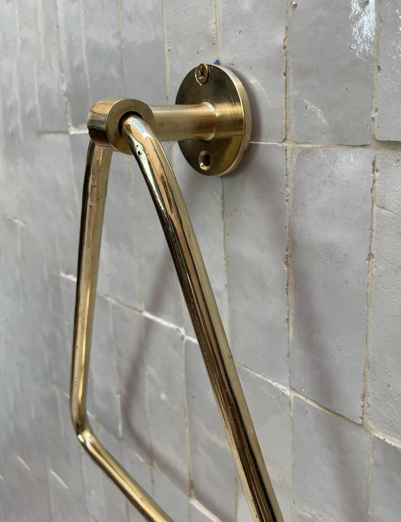 Unlacquered brass wall-mounted towel hanger with golden tone