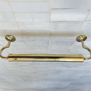 Peut inclure: Un porte-serviettes en laiton poli avec une section centrale cylindrique et des bras de support incurv&eacute;s. La barre est fix&eacute;e avec des plaques murales circulaires. Le luminaire est con&ccedil;u pour une utilisation dans la salle de bain.