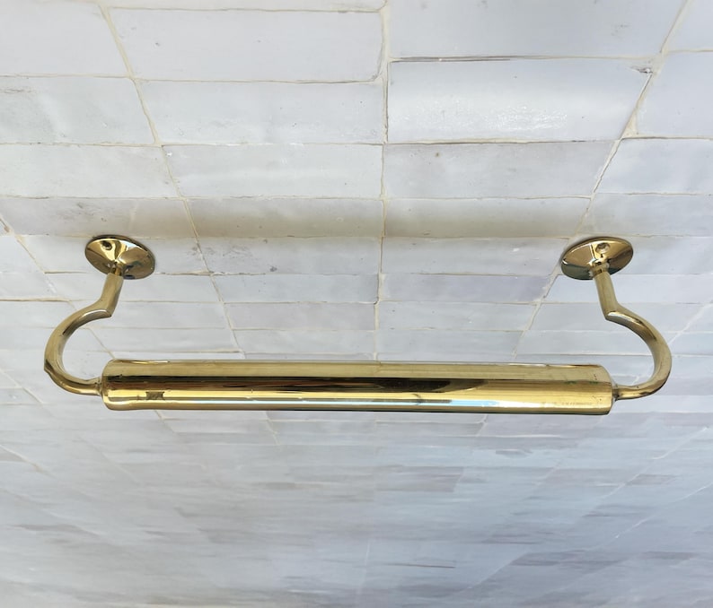 Peut inclure: Un porte-serviettes en laiton poli avec une section centrale cylindrique et des bras de support incurv&eacute;s. La barre est fix&eacute;e avec des plaques murales circulaires. Le luminaire est con&ccedil;u pour une utilisation dans la salle de bain.
