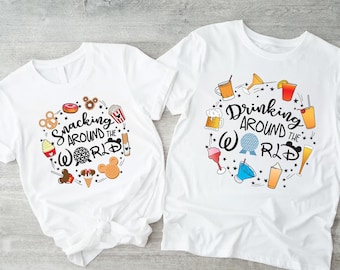 May include: Two white t-shirts with a graphic design on each. The left shirt says "Snacking Around the World" with a circle of food and Disney icons. The right shirt says "Drinking Around the World" with a circle of drinks and Disney icons.