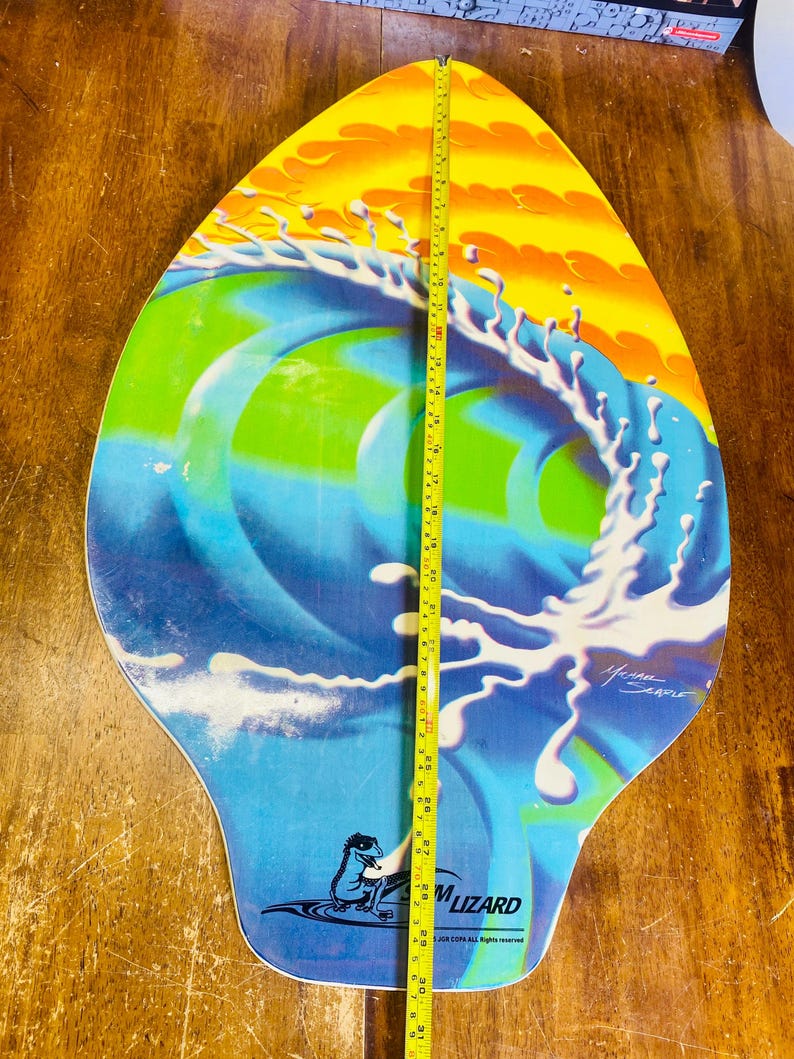 May include: A blue, green, yellow, and white surfboard with a wave design and the text "Foam Lizard" and "For COPA All Rights Reserved". The surfboard is 30 inches long.