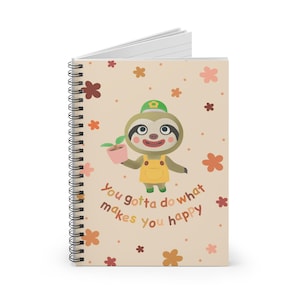 May include: A beige spiral-bound notebook with a cartoon sloth illustration on the cover. The sloth is wearing a yellow outfit and a green hat, holding a plant. The cover also has flower illustrations and the text "You gotta do what makes you happy."