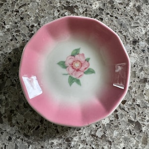 May include: A set of three ceramic mugs with a speckled, matte finish. The mugs are in shades of cream, light gray, and dark gray. Each mug has a simple, minimalist design and a rounded handle.
