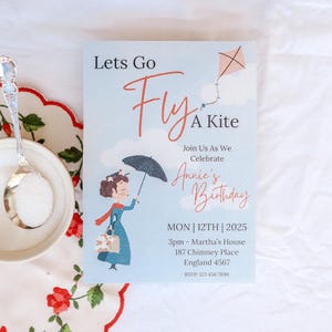 Puede incluir: Una tarjeta de invitación azul y blanca con una cometa roja y blanca, una niña con una bufanda roja y un vestido azul sosteniendo un paraguas, y el texto "Lets Go Fly A Kite" y "Annie's Birthday".