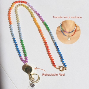 Puede incluir: Un cord&oacute;n hecho de cuentas multicolores en degradado de arco&iacute;ris, con un carrete retr&aacute;ctil en tono dorado y un anillo de sujeci&oacute;n circular. Un recuadro muestra el art&iacute;culo como un collar con un colgante circular con la letra N.