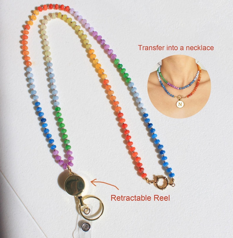 Puede incluir: Un cord&oacute;n hecho de cuentas multicolores en degradado de arco&iacute;ris, con un carrete retr&aacute;ctil en tono dorado y un anillo de sujeci&oacute;n circular. Un recuadro muestra el art&iacute;culo como un collar con un colgante circular con la letra N.
