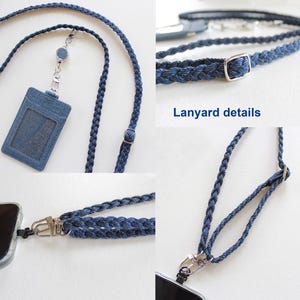 May include: A dark blue braided lanyard featuring a matching denim-textured ID card holder and a retractable reel. The strap includes a silver-toned metal slider for length adjustment and a swivel clasp for attaching to a mobile phone case.