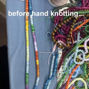 Puede incluir: Una colecci&oacute;n de cuentas de vidrio multicolor en hilos, incluyendo una hebra larga con un degradado de arco&iacute;ris y un carrete de hilo. El texto 'before hand knotting...' es visible. Una regla muestra medidas en cent&iacute;metros junto a las cuentas.