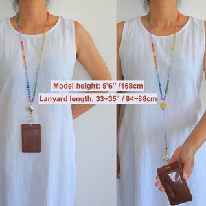 Puede incluir: Un cord&oacute;n de cuentas con los colores del arco&iacute;ris que incluye un carrete retr&aacute;ctil y un porta credenciales vertical marr&oacute;n. La longitud es de 84 a 88 cm. El texto dice: Model height: 5'6" /168cm y Lanyard length: 33~35" / 84~88cm.