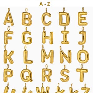 Puede incluir: Una colecci&oacute;n de dijes de letras de metal de color dorado de la A a la Z, cada uno con una peque&ntilde;a anilla circular en la parte superior para su fijaci&oacute;n. Las letras tienen un aspecto liso, redondeado y abombado con acabado met&aacute;lico.