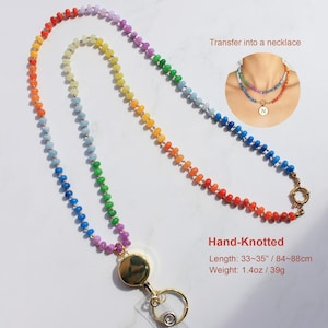 Puede incluir: Un cord&oacute;n de cuentas con los colores del arco&iacute;ris, un carrete retr&aacute;ctil dorado y un llavero. El texto incluye: Transfer into a necklace, Hand-Knotted, Length: 84-88cm, Weight: 39g.