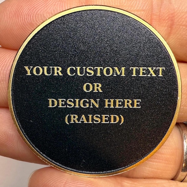 May include: A black round metal disc with a gold rim. The disc has gold lettering that reads "YOUR CUSTOM TEXT OR DESIGN HERE (RAISED)"