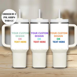 May include: Three white stainless steel travel mugs with a handle and a lid. Each mug has a silver band around the middle and the text "YOUR CUSTOM DESIGN OR TEXT HERE" in colorful letters.