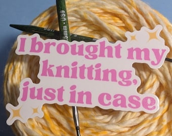 May include: A white sticker with pink text that reads "I brought my knitting, just in case" with small yellow star accents. The sticker is placed over a ball of yellow and white variegated yarn and two dark green knitting needles with 5.5mm US9 markings.