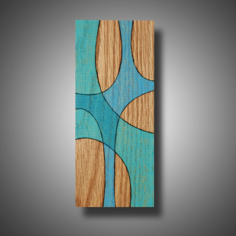 May include: Abstract wood wall art with a blue and brown design. The wood is stained in a light brown color and the design is made up of overlapping circles and lines in shades of blue.