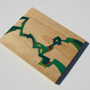 Puede incluir: Una pieza de arte de pared de madera con un dise&ntilde;o abstracto en verde, rojo y amarillo.
