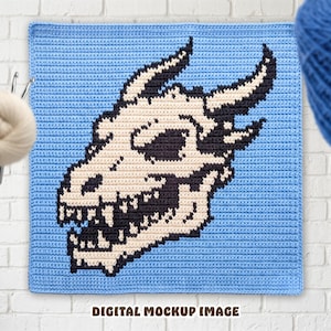 May include: A square crochet panel featuring a pixelated design of a horned animal skull in cream and black yarn against a light blue background. The text DIGITAL MOCKUP IMAGE is printed in brown at the bottom of the square crochet piece.