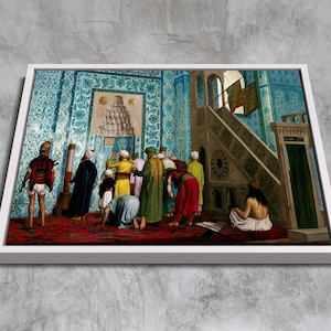 May include: A painting depicting a group of people in traditional clothing gathered inside a mosque. The mosque has blue and white tiled walls and a patterned ceiling. The people are facing a prayer niche, with some kneeling and others standing. The painting is framed in a white frame.