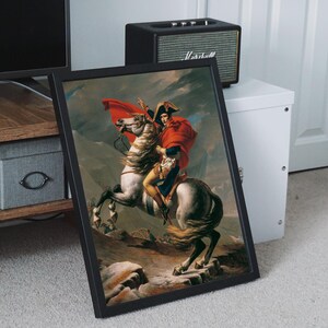 May include: A framed painting of a man on horseback, wearing a red coat and a white hat. The horse is white and is galloping up a hill. The painting is set against a backdrop of a mountainous landscape.