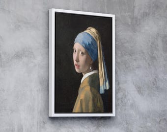 Puede incluir: Una pintura enmarcada de una mujer con un pañuelo azul y amarillo y un pendiente de perla. La mujer mira hacia un lado y tiene una expresión suave en su rostro.