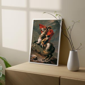 May include: A framed painting of a man on horseback, riding through a mountainous landscape. The man is wearing a red cloak and a white hat. The horse is white with a brown saddle. The painting is set against a backdrop of a stormy sky.