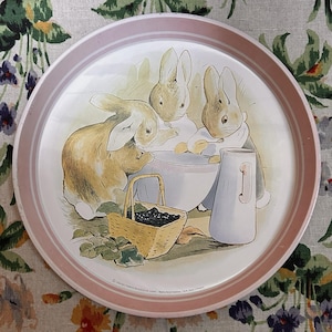 May include: A white ceramic mug with a black handle and the text "But First, Coffee" in a bold, black font. The mug is set against a neutral background, highlighting its simple design.