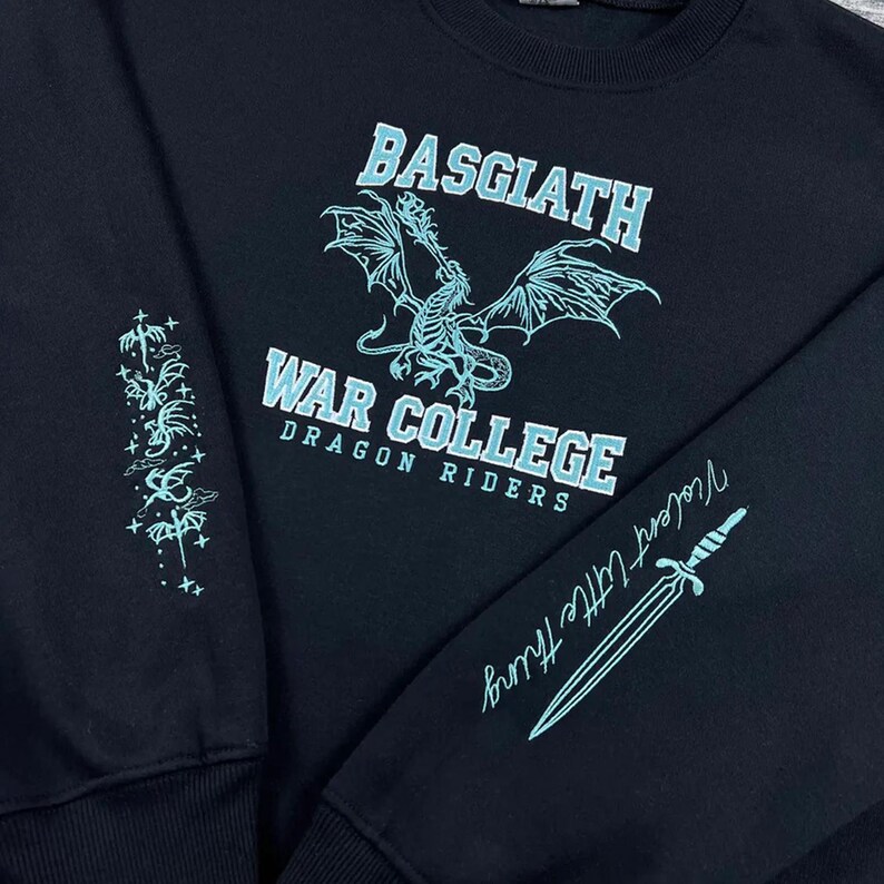 May include: Black sweatshirt with the text "BASGIATH WAR COLLEGE DRAGON RIDERS" in light blue. A dragon graphic is centered above the text. The sleeve has a design and the words "Violent Little Thing" with a sword graphic.