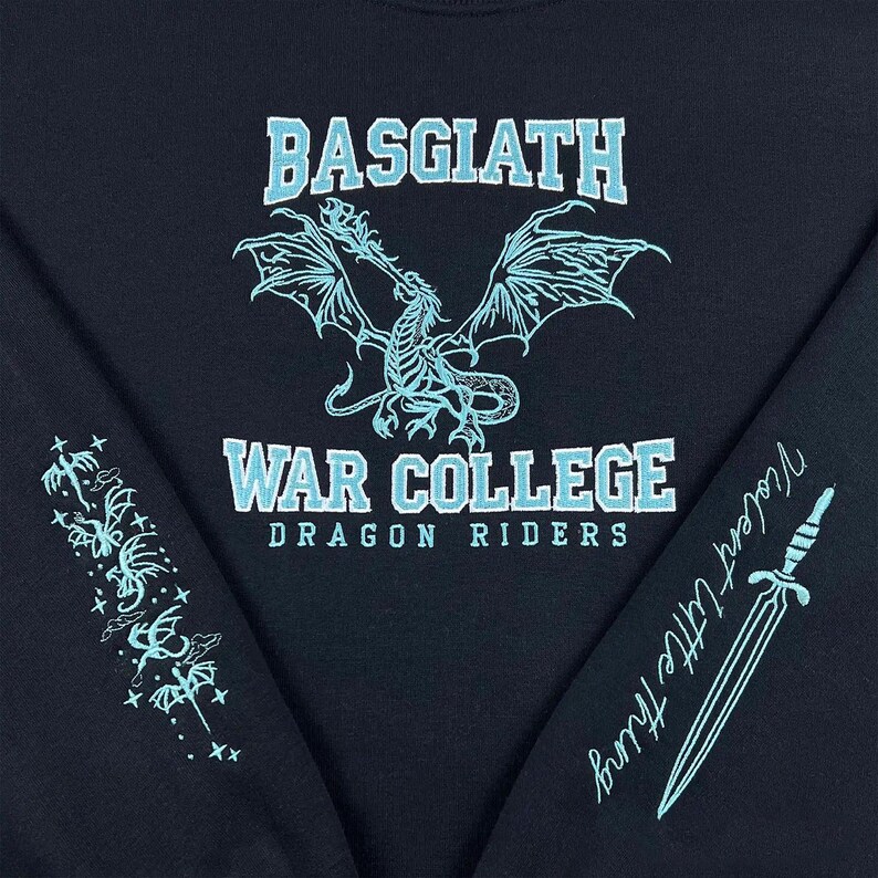May include: Black sweatshirt with light blue text and graphics. The front features a dragon design and the words "BASGIATH" and "WAR COLLEGE DRAGON RIDERS." The left sleeve has a floral design, and the right sleeve has a sword and the words "Violent Little Thing."