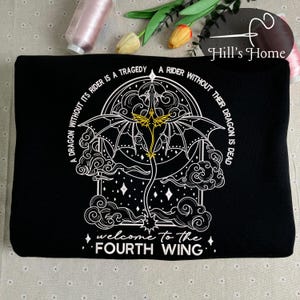 May include: Black sweatshirt with a white embroidered design of a dragon with wings spread. The design is surrounded by a circle with the text "A dragon without its rider is a tragedy. A rider without their dragon is dead. Welcome to the Fourth Wing."