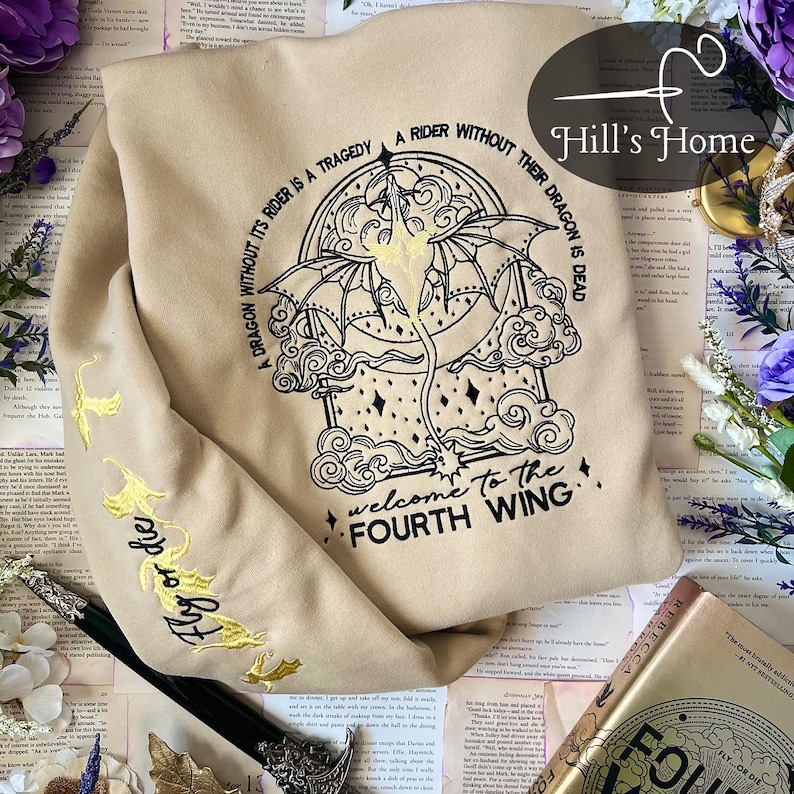 May include: A tan sweatshirt with a black embroidered design of a dragon and clouds. The text "A dragon without its rider is a tragedy. A rider without their dragon is dead. Welcome to the Fourth Wing" is embroidered on the sweatshirt.